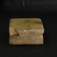 Stone (unknown stone material) block with carved notches for handles and carved grooves on both wider (top and bottom) surfaces